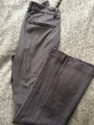 Grå Kostym byxor  - Säljer ett par lågmidjade kostymbyxor från Nelly i Storlek 32, var tyvärr lite för små för mig! Super fint skick! 🌸💕
