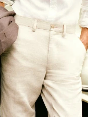 Beiga linnebyxor med rak passform - Snygga beiga linnebyxor med rak passform och klassisk midja. Byxorna har bälteshällor, knappgylf och sidofickor. Perfekta för varma dagar. Tillverkade i lätt och luftigt linnetyg. PRIS KAN DISKUTERAS 