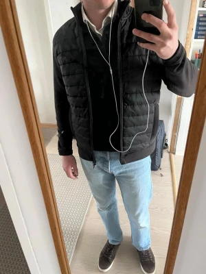 Mörkbrun cardigan  - Säljer en mörkbrun cardigan med quiltad front och släta ärmar. Jackan har hög krage, två sidofickor och hel dragkedja framtill. Perfekt för våren och lite kallare sommardagar! 