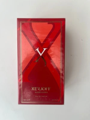Xerjoff Wardasina Eau de Parfum - Lyxig parfym från Xerjoff i serien Wardasina. Flaskan kommer i en elegant röd kartong med gulddetaljer och stor X-logga på framsidan. Innehåller 100 ml Eau de Parfum. Perfekt för dig som gillar exklusiva dofter och snygg design.