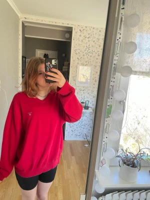 Röd oversized gant tröja - Säljer en röd oversized gant tröja med v-ringning och långa ärmar. Tröjan har en liten broderad gant logga på bröstet och ribbade muddar vid ärmslut och nederkant.