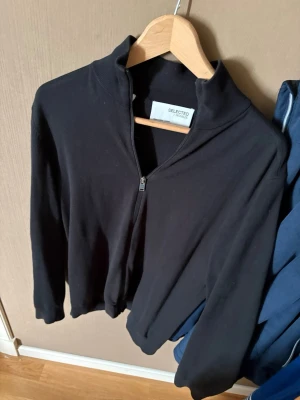 Svart ziptröja från Selected Homme - Svart ziptröja från Selected Homme med hög krage och hel dragkedja framtill. 