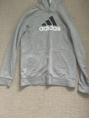 Grå hoodie från Adidas - Fet adidas grå adidas hoodie helt ny aldrig använd. Skönt material och den är inte så tjock perfekt för våren. Priset kan diskuteras.
