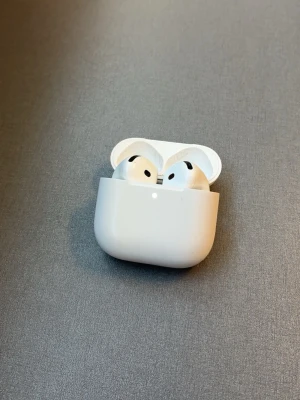Vita trådlösa hörlurar i laddetui - Snygga vita trådlösa in-ear hörlurar med laddningsetui. Hörlurarna har en stilren och kompakt design i plast och laddas via USB-C-port på undersidan av etuiet. Perfekta för musik, poddar och samtal på språng.