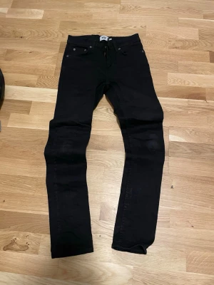 Svarta skinny jeans från lager 157 - Säljer ett par svarta skinny jeans från lager 157 med klassisk femficksmodell och normal midja. Jeansen har smal passform och är tillverkade i stretchigt material för extra komfort. Perfekta till en avslappnad streetstyle-look.