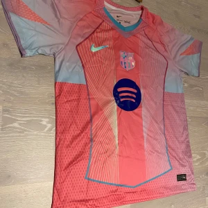 Barcelona rosa 25/26 T-shirt  - •Säljer en jätte stilig 25-26 rosa Barcelona T-shirt.  •Den är inte använd bara testad, jätte bra skick och inga fläckar eller hål.  •Och det är storlek M och måtten finns på dem sista bilderna •Priset kan diskuteras och skickar inom 24 Tim 💨😊