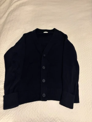 Mörkblå cardigan från John Henric - Klassisk mörkblå cardigan från John Henric. Den är i väldigt gott skick utan några defekter. Det är bara att höra av er om ni har några funderingar!🤩