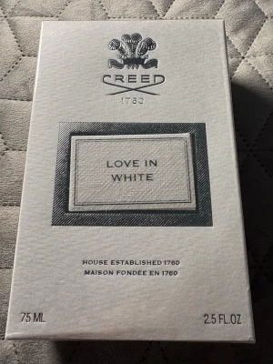 Creed Love in White parfym 75 ml - Lyxig parfym från Creed, Love in White, i elegant vit kartong med silverdetaljer. Flaskan rymmer 75 ml och doften är känd för sin fräscha och sofistikerade karaktär. Perfekt för dig som gillar exklusiva och klassiska parfymer.