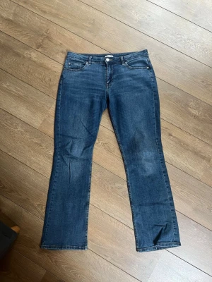 Mörkblå bootcut jeans - Säljer ett par mörkblå bootcut som är mid waist från Cubus. Jeansen har lite stretch men är använda så är lite slitna längst ner på benen. Fråga gärna vid frågor 💕