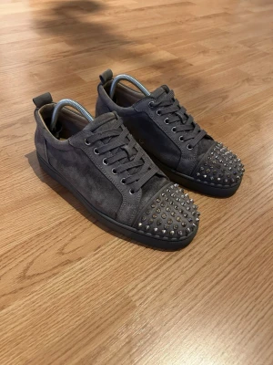 Christian Louboutin skor - Gråa Christian Louboutin skor i väldigt bra skick. Finns lite healdrag. Skornas material är i väldigt bra skick och helheten är väldigt bra. Storlek 42 men kan även passa 43. Tveka inte att kontakta vid minsta lilla fundering. 