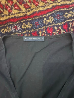 Omlott Tröja  - Brandy melville omlott knyt tröja. Köpt på Sellpy och kommer inte till användning mer. Det står ingen storlek men skulle säga xs-s. Väldigt mörkblå färg. Hör av dig om du vill diskutera pris!🩷