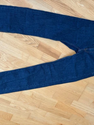 Mörkblå regular fit jeans Dressmann - Snygga mörkblå jeans från Dressmann i modellen regular fit. Klassisk femficksdesign med kontrastsömmar och robust känsla. Perfekta till vardagslooken och tillverkade i slitstarkt denimtyg.