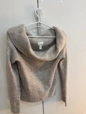 Ljusgrå stickad off shoulder H&M - Mysig ljusgrå stickad off shoulder tröja i storlek M
