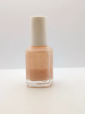 Essie Petal Pink nagellack 15ml 35% kvar - Essie nagellack i färgen Petal Pink, en mjuk och ljusrosa nyans som ger en fräsch och naturlig look till naglarna. Kommer i en klassisk fyrkantig glasflaska med vitt skruvlock. Innehåller 15 ml och är perfekt för dig som gillar subtila pastelltoner.