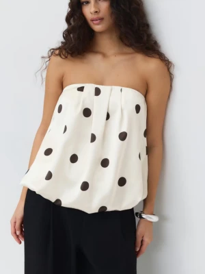 Vit prickig tubtopp - Säljer en vit tubtopp med stora svarta prickar. Toppen är axelbandslös och har en luftig passform som ger en cool och avslappnad look. Perfekt för dig som vill sticka ut med ett trendigt mönster.