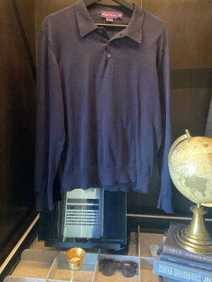 Ralph lauren purple label  - Klassisk mörkblå långärmad pikétröja från Ralph Lauren Purple Label. Snygg krage och knappar framtill ger en clean look. Tillverkad i mjukt material, perfekt för dig som gillar stilrena plagg med premiumkänsla. Tröjan kostar runt 5000-10,000 ny! Den är i nyskick, passar S men M också!