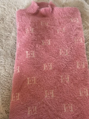 Rosa mjuk långärmad tröja - Supersjuk rosa stickad långärmad tröja. Testad en gång. Fick den i Spanien av min chef när jag slutade där. Kliar ej lite högre hals men skulle nog inte räkna den som en polo. Någon typ av logo på den. Storlek lx/xxl men passar som en s. 