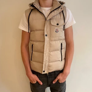  Monclerväst med huva - Säljer en beige dunväst från Moncler med huva. S men stor i storleken ! Modellen är 187 och ca 70 kg. Passar perfekt till våren 🍀! Skriv om du har några funderingar 💫