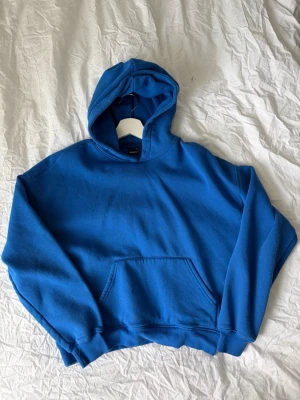 Blå hoodie  - Blå hoodie med tryck på ryggen som är använd ca 3 ggr 🤍 har fått missfärgningar (se näst sista bilden) syns dock inte om man inte kollar nära 🤍 