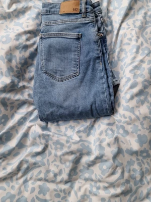 Low waist jeans - Säljer ett par ljusblå low waist jeans från Lager 157 med klassisk femficksdesign och low waist  midja. Jeansen har en snygg tvättad look och är tillverkade i mjukt denimtyg med stretch för extra komfort. Perfekta till en avslappnad stil. Kostade 200 kr i butik aldrig använda.