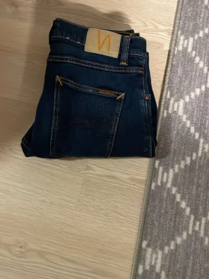 Mörkblå jeans från Nudie Jeans - Säljer nu dessa nudie jeans som är näst intill oanvända och som är förstora pga diverse anledningar. Passformen ör lean dean samt W31L30. Mvh, af Klint.