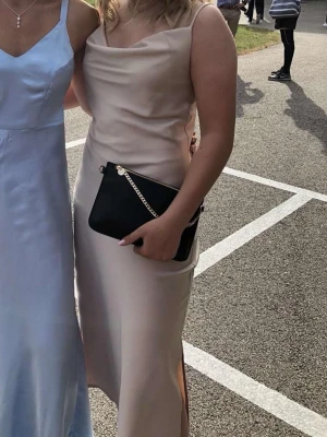 Champagnefärgad långklänning med slits - Elegant långklänning i champagnefärg med smala axelband och slits på sidan. 