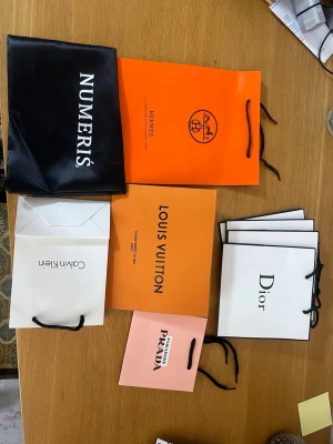 Mix av shoppingpåsar från kända märken - Om du köper så skickar jag allt. Inget fel med de. Säljer de då de inte kommer till någon nytta här hemma :). Det kommer med: 4st dior packing bags, 1 prada, 1 Hermes, 1 louis vuitton, 1 CK och två Numeris påsar.