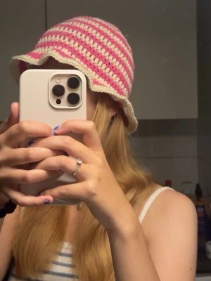 Virkad rosa och vit bucket hat - Egenvirkad buckethat i vitt och rosa garn. Handtvätt rekommenderas utan sköljmedel eller ett lugnt program på tvättmaskinen i tvättpåse.