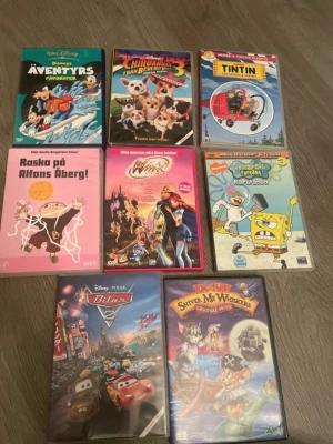 Samling med 9 barnfilmer på DVD - Säljer en samling med 9 olika barnfilmer på DVD, bland annat Disney, Alfons Åberg, Tintin, Svampbob Fyrkant och Barbie. Omslagen är färgglada och filmerna är i plastfodral. Perfekt för dig som gillar klassiska och tecknade filmer.