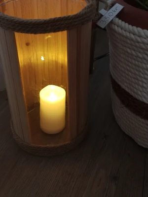 Stor ljuslykta i trä och rep - Säljer en stor, cylinderformad ljuslykta i ljust trä med repdetaljer upptill och nedtill. Lyktan har glasväggar och plats för ett blockljus inuti, vilket ger ett mysigt sken. Perfekt som inredningsdetalj för att skapa stämning hemma.