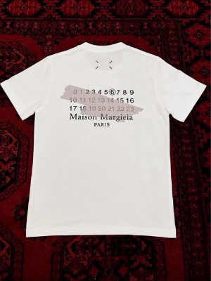 Maison Margiela t-shirt - Vit t-shirt från Maison Margiela perfekt för sommar outfits. | skick : 10/10 har endast använts fåtal gånger så ser ut som ny. | etiketten och påsen följer med på köp! | Storlek EU S| längd : 64 cm | bredd : 46 cm | pris går att diskutera vid bundle köp / snabbaffär! 💯