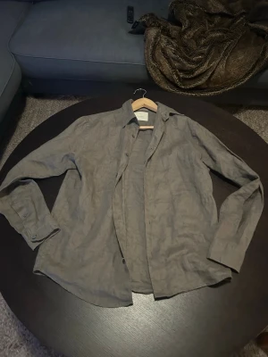 Grön linneskjorta från Jack & Jones - Snygg grön skjorta från Jack & Jones i luftigt linne. Skjortan har klassisk krage, knappar framtill och långa ärmar med knapp vid manschetten. Perfekt för dig som gillar en enkel och stilren look. Knappast använd max 2 gånger.