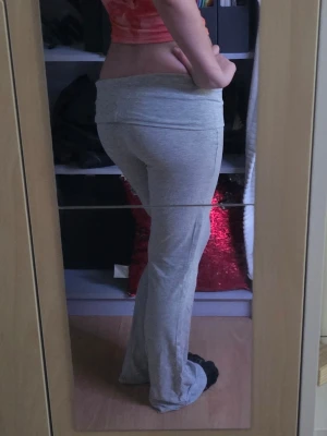 Grå bootcut mjukisbyxor - Säljer ett par grå mjukisbyxor med bootcut-modell och bred, vikt linning från Gina. Byxorna är i mjukt och stretchigt material, perfekta för en avslappnad stil. Passar dig som gillar bekväma och trendiga byxor.