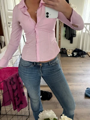 Blåa slim fit jeans med hög midja - Snygga blåa slim fit jeans med låg midja och klassiska fem fickor. Jeansen har en lätt tvättad look och smal passform som framhäver figuren. Perfekta att matcha med en skjorta eller t-shirt för en trendig stil.
