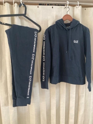 EA7 Armani tracksuit svart L äkta set hoodie mjukis trend - Stilrent och eftertraktat set från EA7 Emporio Armani – hoodie + byxor i matchande design med tydliga logodetaljer.  ✔️ 100% äkta (Certilogo/QR) ✔️ Storlek: L ✔️ Färg: Svart ✔️ Skick: Mycket fint  Sportig, clean och exklusiv look – perfekt till vardag/streetwear.  Säljes som komplett set  🔥 Populärt set – går snabbt OBS: Finns även på andra plattformar – först till kvarn