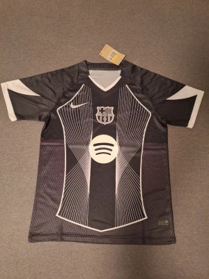Barcelona Black Special Kit 2025  - Stilren och eftertraktad specialutgåva från Barcelona 2025 i helsvart design. En unik tröja som sticker ut från de klassiska färgerna och passar perfekt både till match och vardag. Populär modell som är svår att få tag på, vilket gör den extra attraktiv för samlare och fans.  Skicka gärna meddelande vid frågor