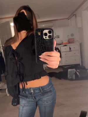 Volang blus  - Svart blus från vero Moda med volanger och blommigt ihåligt mönster på ärmarna , man knyter tröjan framtill❤️