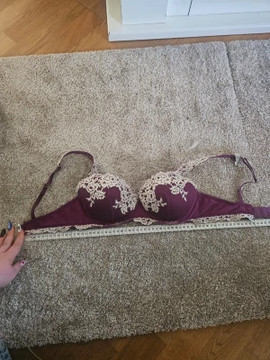 Lila bh med spetsdetaljer från intimissimi  - Snygg lila bh med vadderade kupor och snygga vita spetsdetaljer. !!Den är insydd så den är 67 istället för 70-75 runt så den motsvarar ish 70D så mät gärna runt först och somsagt den har samma kupa som en 75C har