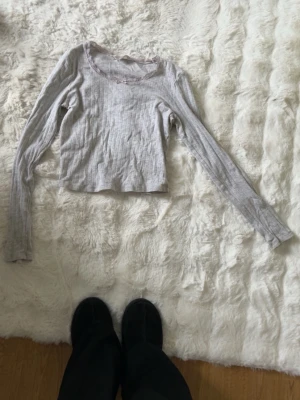 Grå ribbad loungetröja H&M - Supermjuk och ribbad grå långärmad loungetröja från H&M. Tröjan har spetskant och en liten rosett vid halsringningen, samt diskret mönster i tyget. Perfekt för mysiga hemmadagar. Och de är jätte gullig!🥰