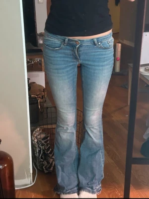 Ljusblå bootcut jeans med låg midja - Säljer ett par ljusblå bootcut jeans med låg midja och klassiska fem fickor. Jeansen har en lätt tvättad look och utsvängda ben. Perfekta för en avslappnad och trendig stil. Fri frakt!