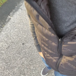 Svart dunväst från H&M, storlek M - Säljer nu en svart dunväst från H&M i storlek M. Den är lätt vadderad och har en stilren och enkel look .
