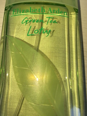 Elizabeth Arden Green Tea Lotus parfym - Fräsch parfym från Elizabeth Arden med doft av grönt te och lotus. Flaskan är transparent med ljusgrön vätska och har ett stilrent bladmotiv på framsidan. Perfekt för dig som gillar lätta och naturliga dofter.