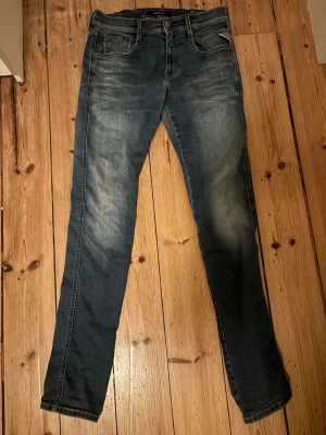 Blå slim fit jeans från Replay - Snygga blå slim fit jeans från Replay, rätt bra skick, har använt dem flitigt men ändå snygga, en liten defekt i mitten av jeansen, men kan sys ihop! 30/32 i storleken.