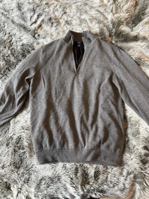 Grå halvzip-tröja från Callaway - Snygg grå tröja från Callaway med halv dragkedja och ribbade muddar. Tröjan är vindtät vilket gör den perfekt för våren osv. Perfekt golftröja. 