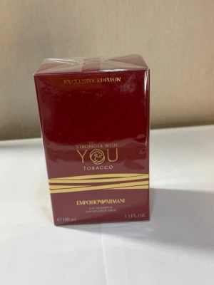 Emporio Armani Stronger With You Tobacco - Emporio Armani Stronger With You Tobacco Exclusive Edition är en parfym i en lyxig mörkröd kartong med gulddetaljer. Doften är en eau de parfum och flaskan rymmer 100 ml. Förpackningen har exklusiv känsla och är märkt med Sephora.