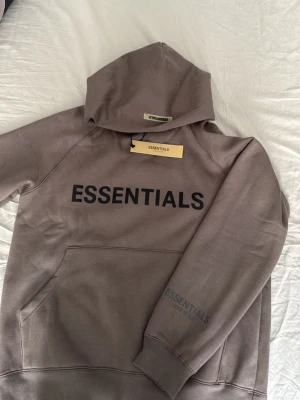 Grå essentials hoodie - Säljer en grå essentials hoodie aldrig andvänd skick 10/10 sprillans ny den är i storlek S