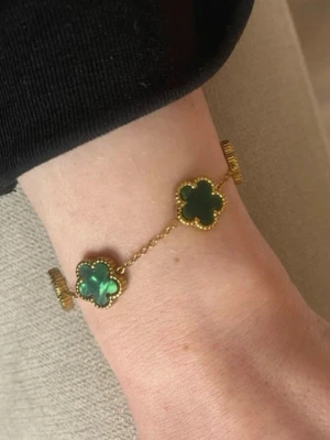 Armband med gröna stenar  - Liknar ett känt armband. Själva armbandet är 17 cm ca, 23 cm hela. Typ mässing, det är i alla fall inget äkta smycke.
