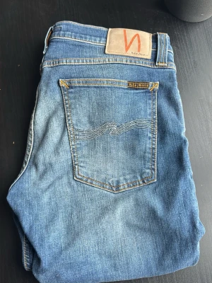 Snygga Nudie Jeans - Säljer ett par blå jeans från Nudie Jeans med slim passform och med en fin ”washed” look. Perfekta för dig som gillar stilrena och tidlösa jeans i mjukt denimtyg. De är i mycket bra skick!!                           Skriv om ni funderar över något!!