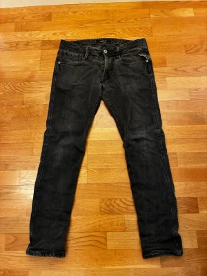 Svarta slim fit jeans från replay - Snygga svarta jeans från replay i slim fit-modell. Jeansen har klassisk femficksdesign, dragkedja och knapp i midjan samt diskreta slitningar för en cool look. Materialet är mjukt denim