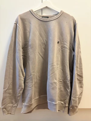 Grå sweatshirt från Dondup - Grå sweatshirt från Dondup i storlek XL, motsvarar mer en L. Tröjan har två små fläckar vid vänster axel, se sista bilden.
